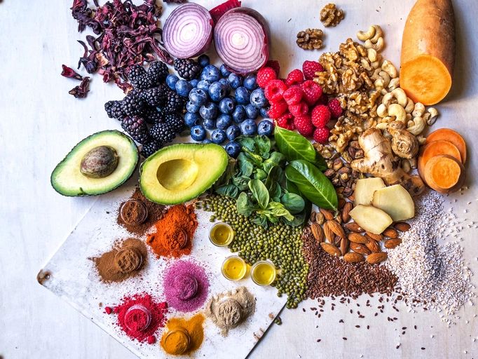 Assorted fresh vegetables, fruits, legumes, nuts and spices on a wooden table